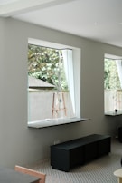 Interior view of a minimalist living room with natural light and bespoke furniture.