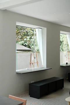 Wide shot of an open-plan interior with minimalist furniture and large windows.