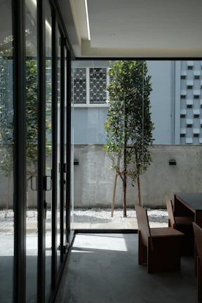 Outdoor patio featuring folding glass doors opening to a garden with natural light