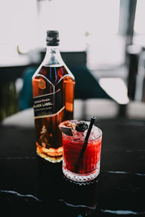 a bottle of alcohol and a glass on a table