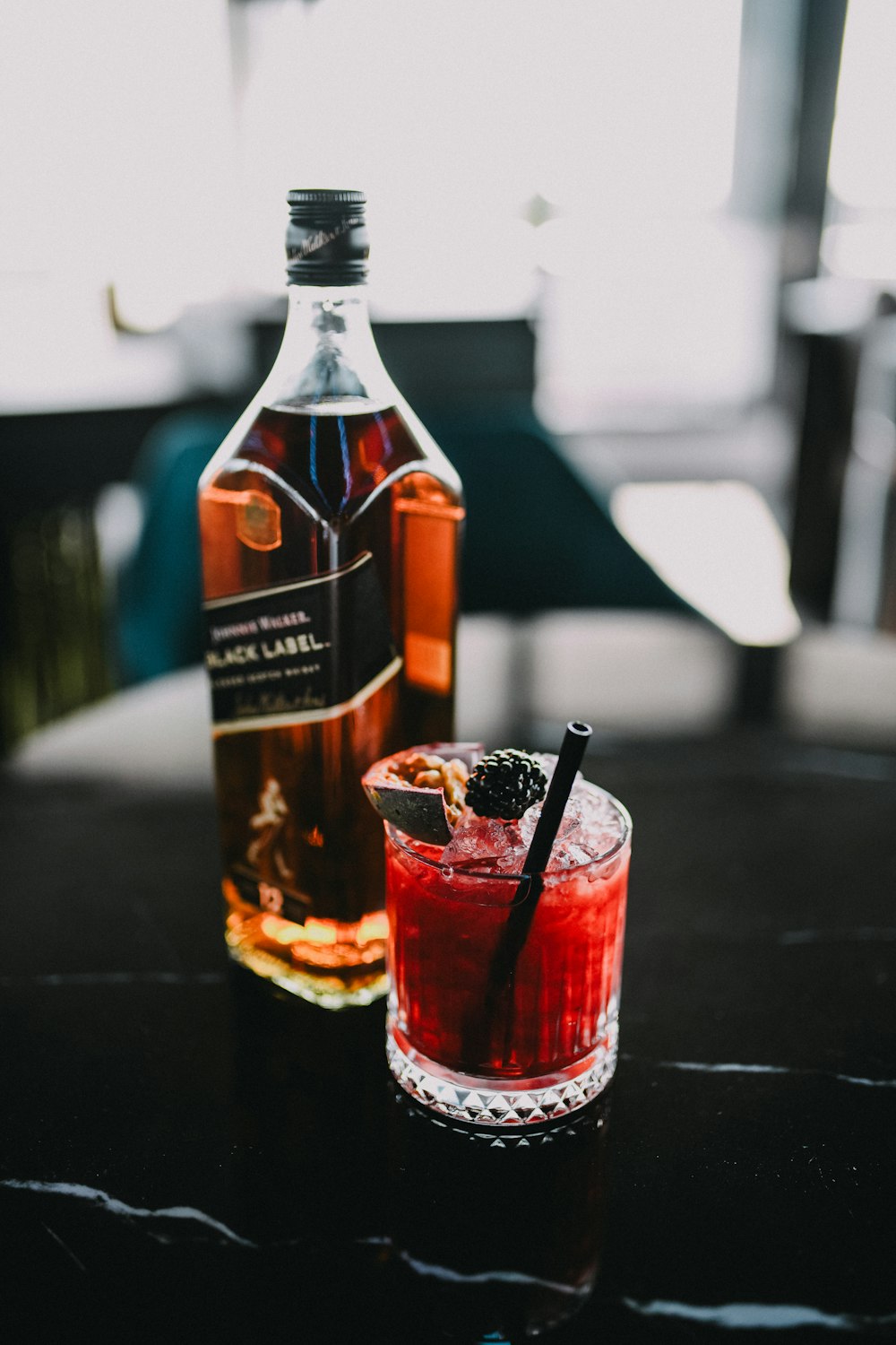 a bottle of alcohol and a glass on a table