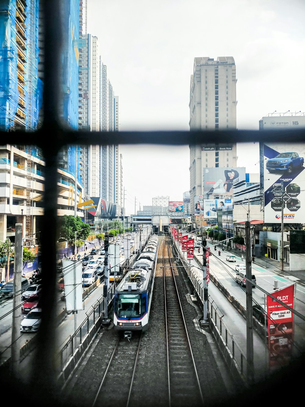 a train traveling down train tracks next to tall buildings