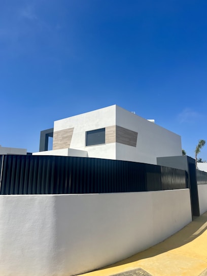 Modern minimalist home exterior with clean lines and natural landscaping at sunset.