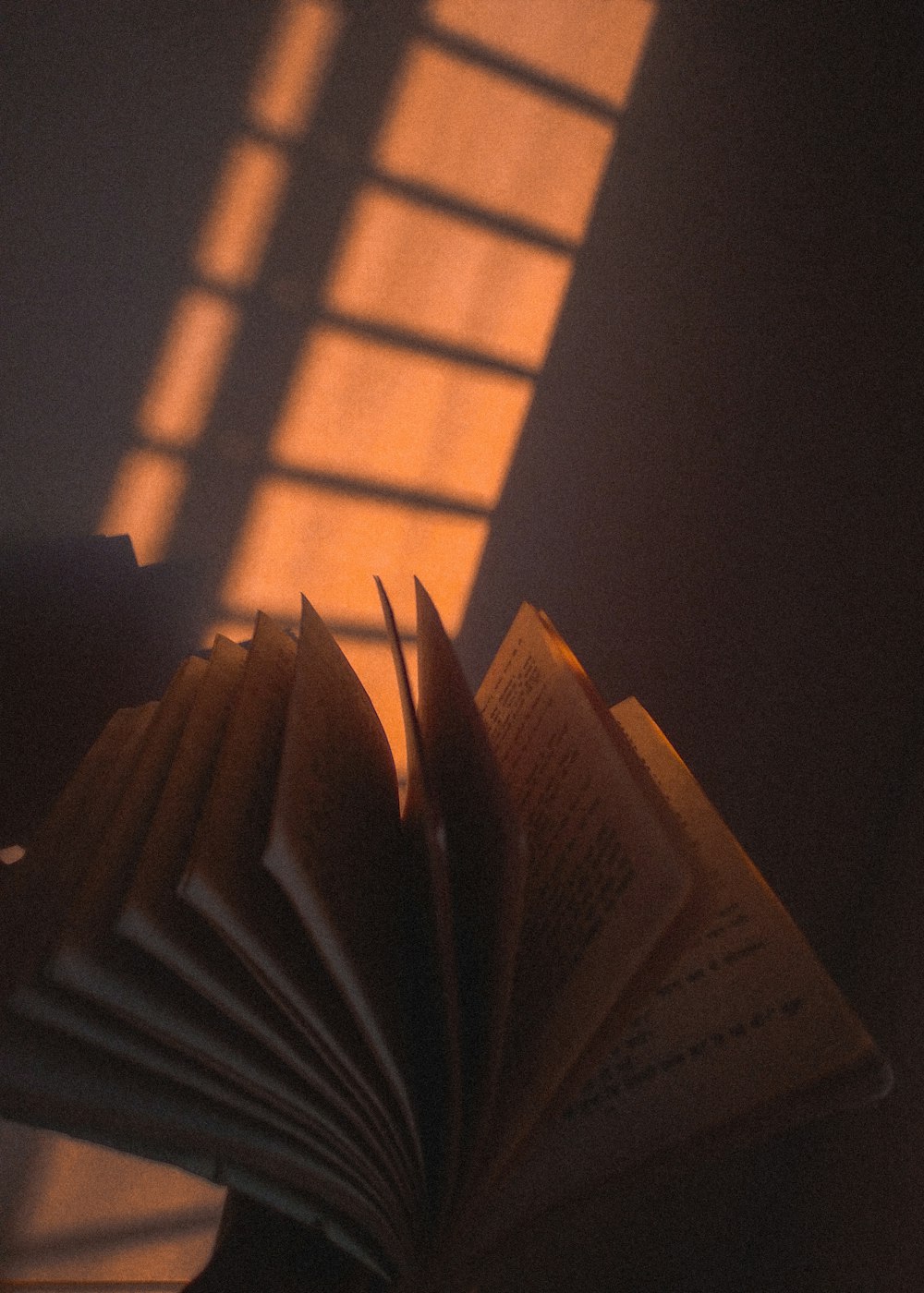 an open book sitting on top of a table next to a window