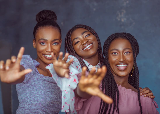 A group of diverse women caregivers smiling and interacting warmly in a community setting in Cali.