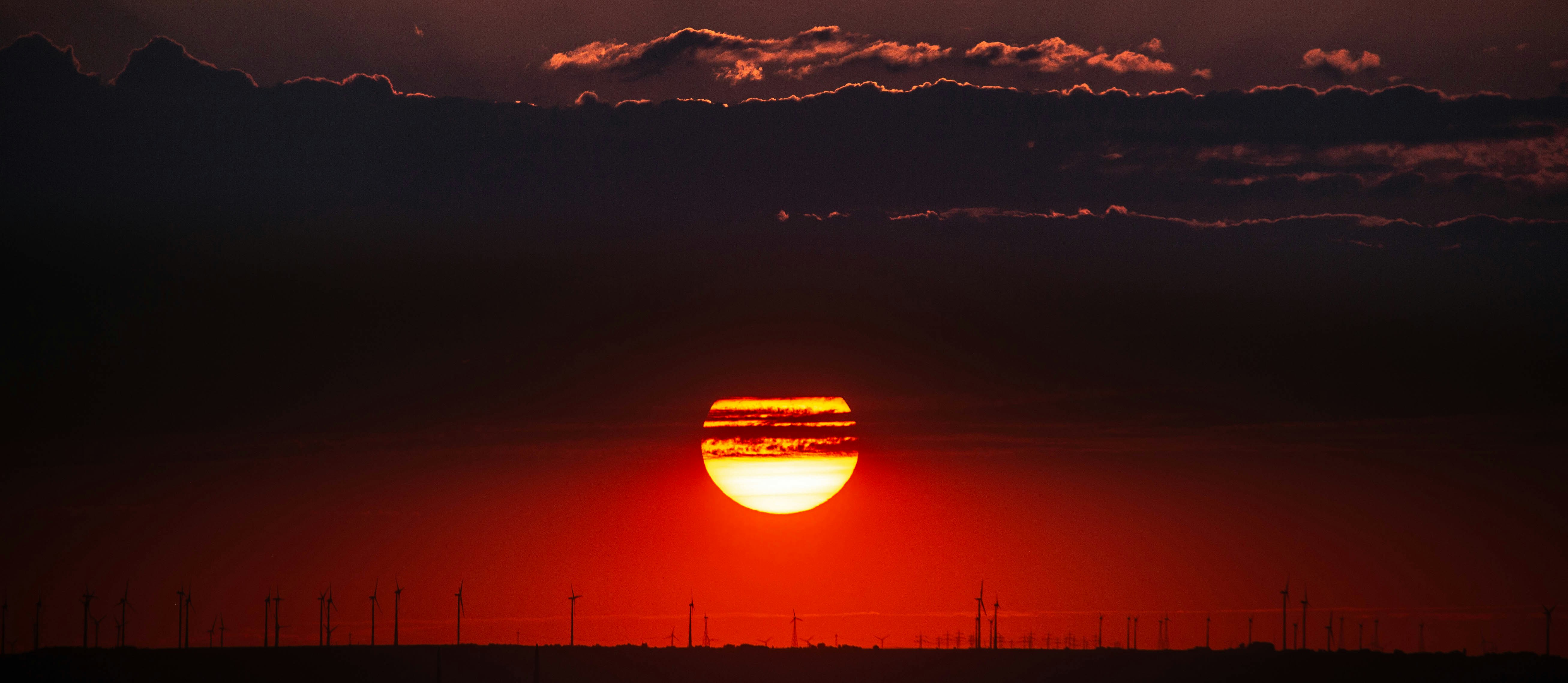 the sun is setting in the sky over a field