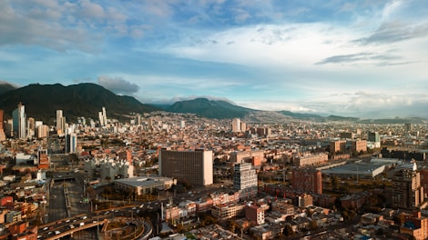 an aerial view of a city with mountains in the background