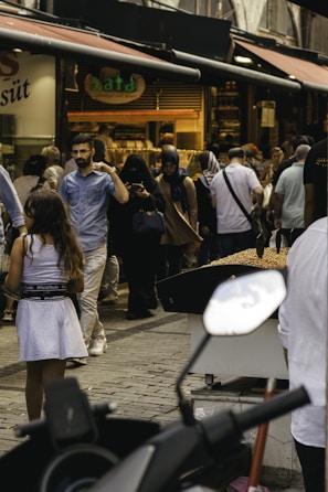 A bustling city street with diverse people enjoying an outdoor market.