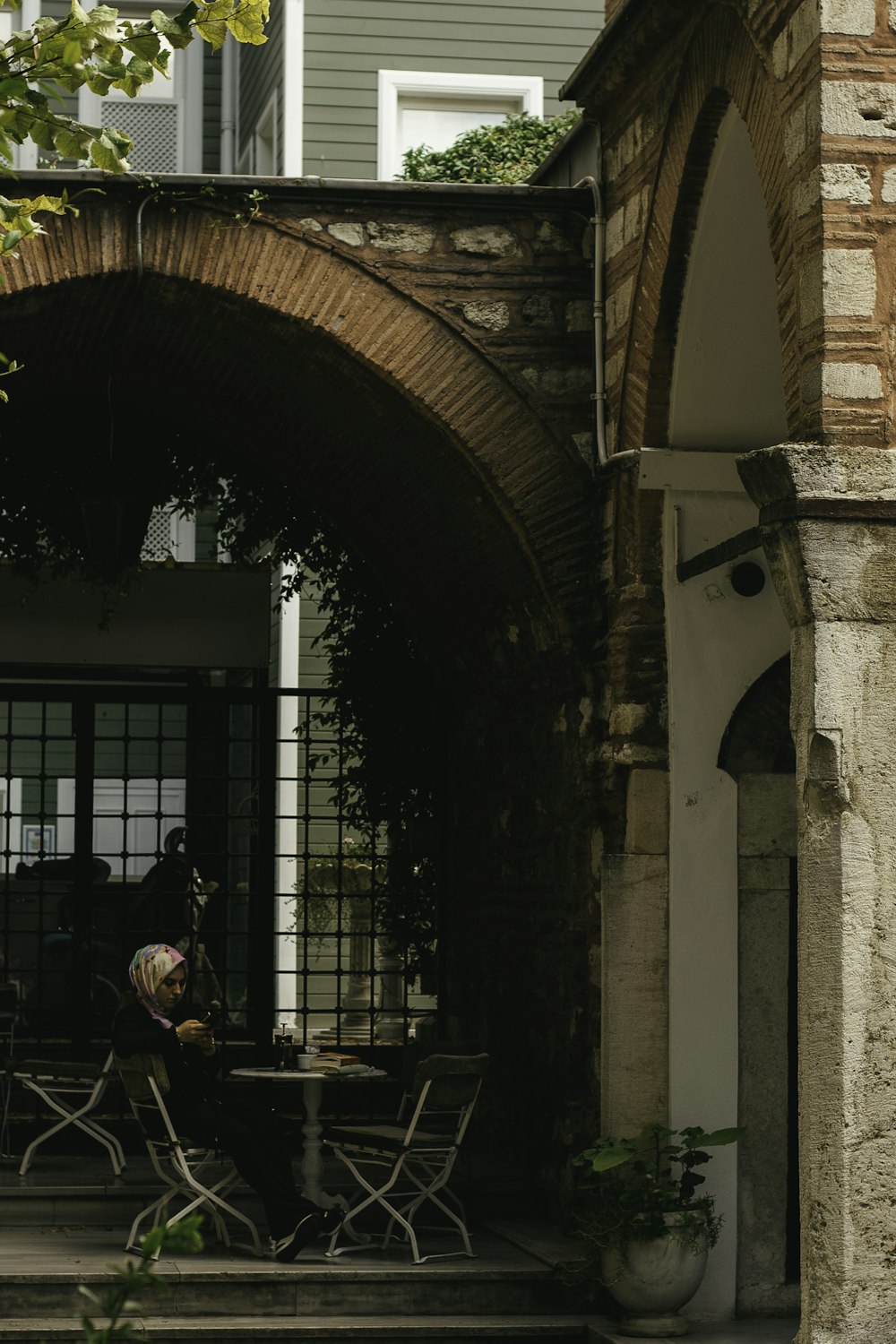 a person sitting at a table outside of a building