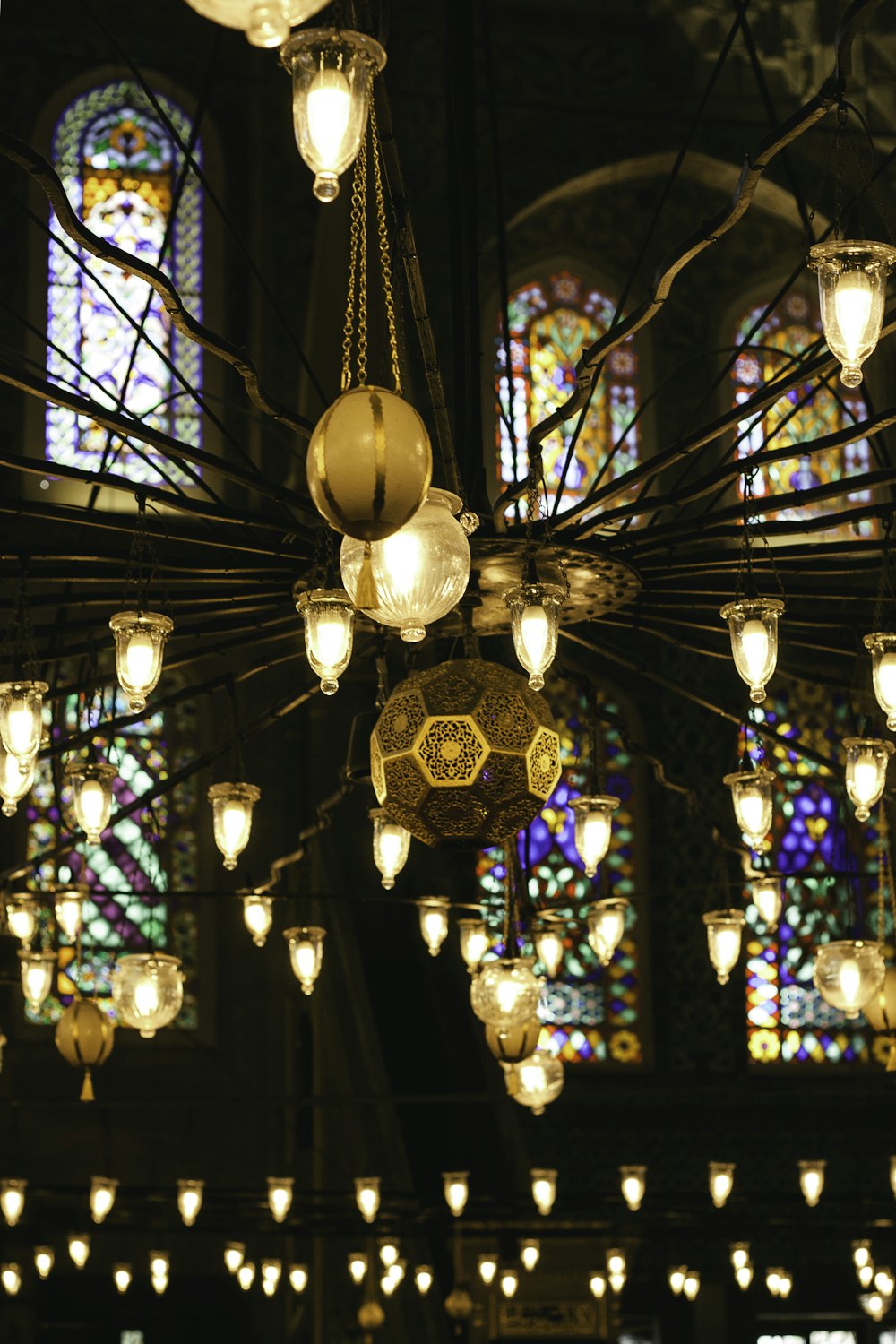 um lustre pendurado em um teto em frente a um vitral