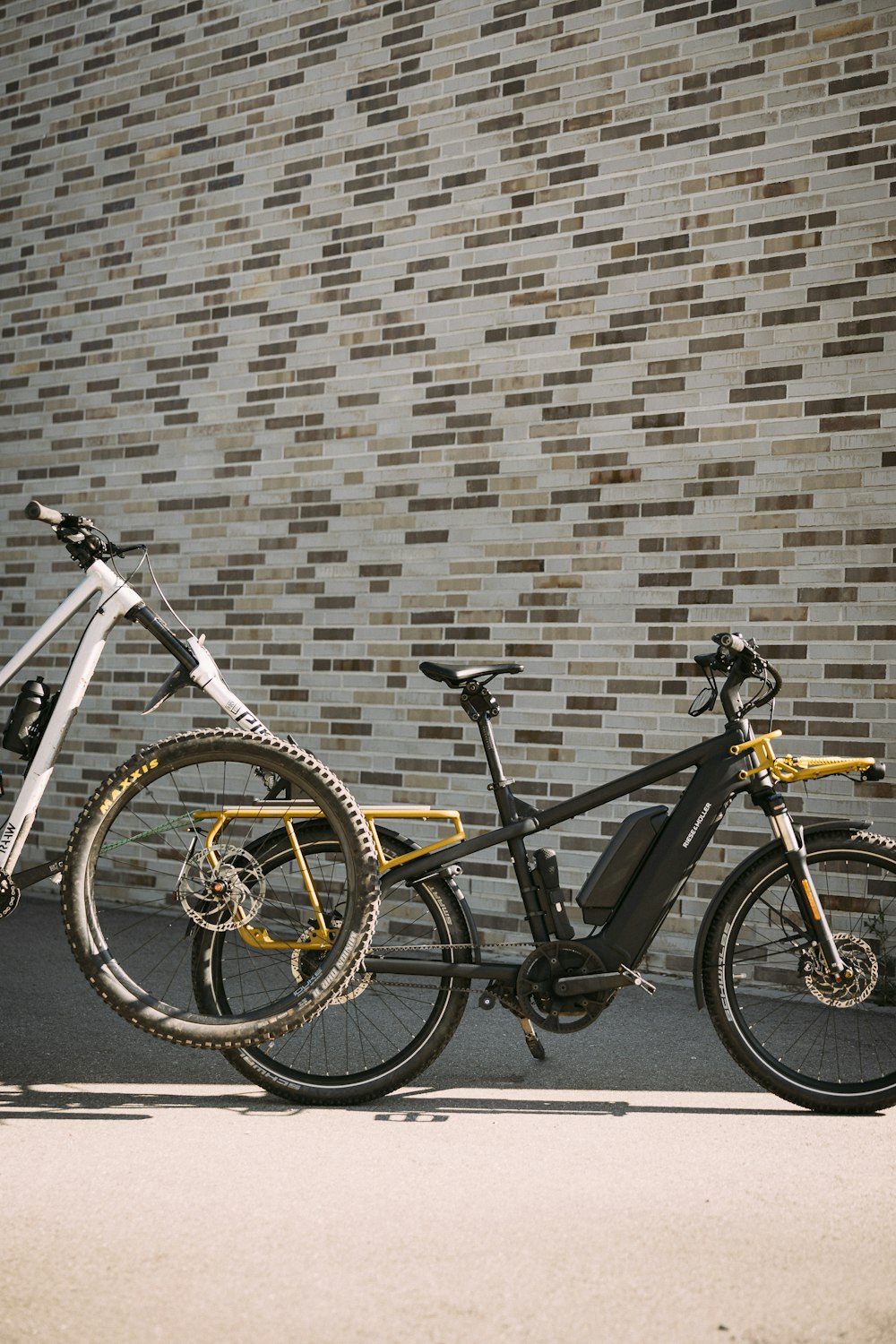 two bikes parked next to each other in front of a brick wall