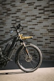 a bike parked next to a brick wall