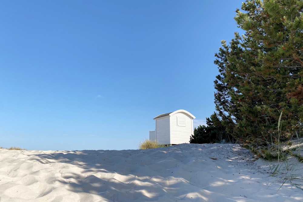 a white building sitting on top of a sandy hill