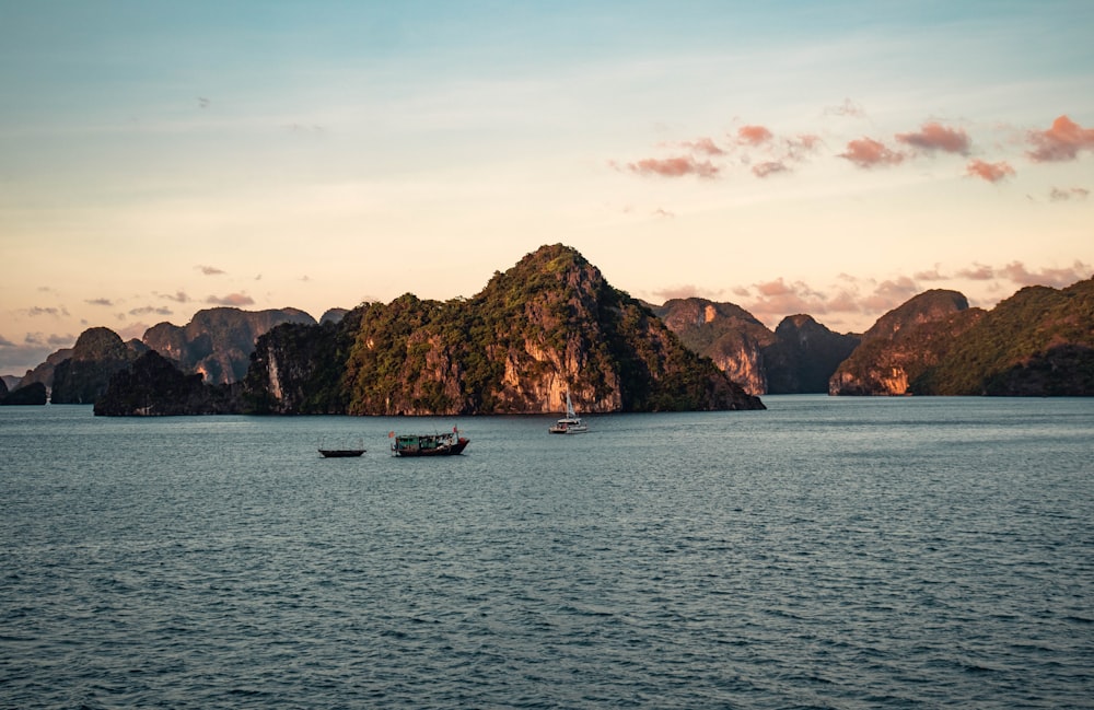 a couple of boats floating on top of a large body of water