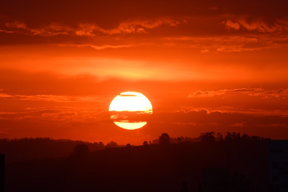 the sun is setting over the horizon of a city