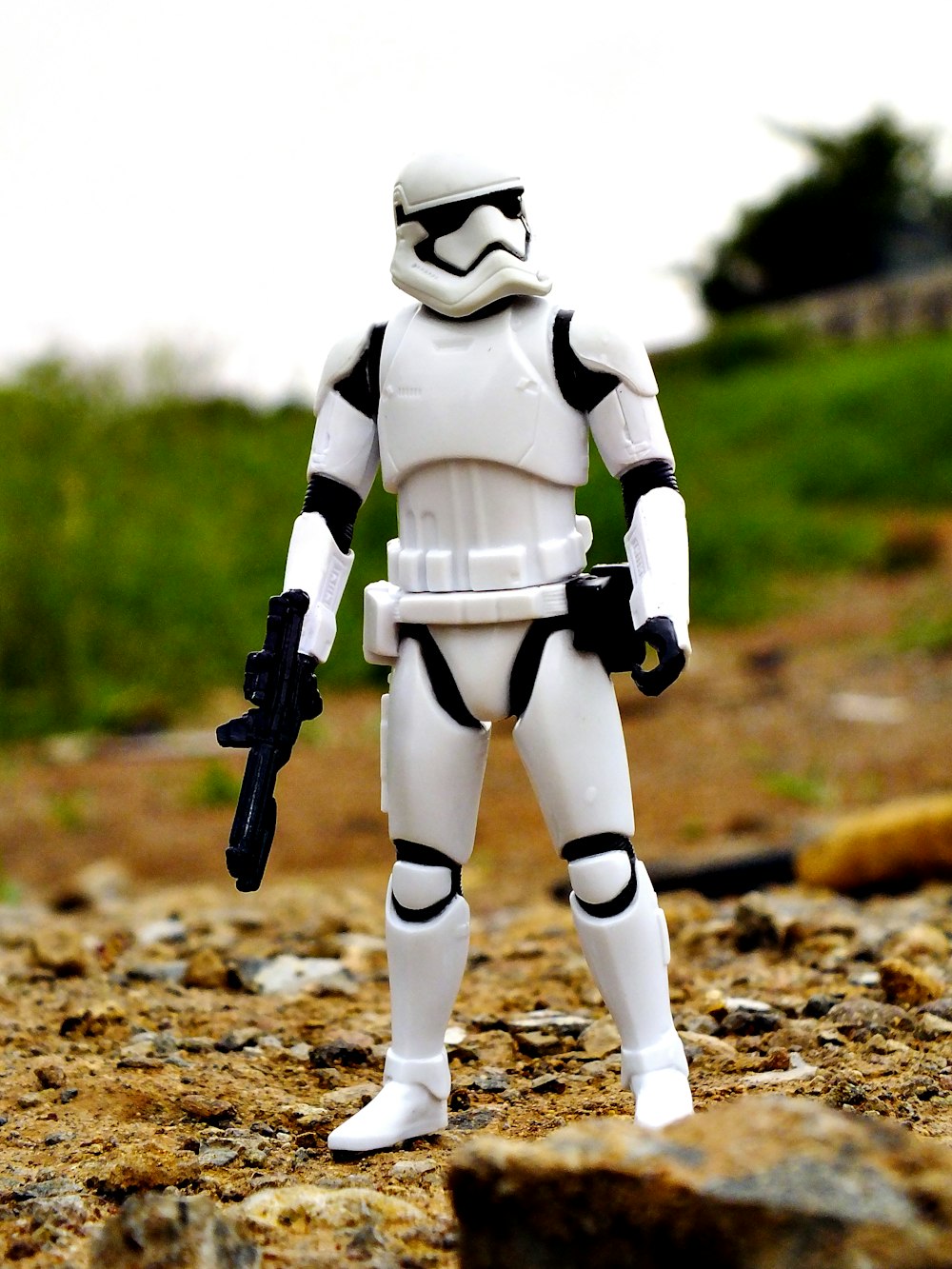 Uma figura de ação de Star Wars em pé na sujeira