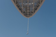 An exhilarating bungee jump with a jumper mid-air against a clear sky.