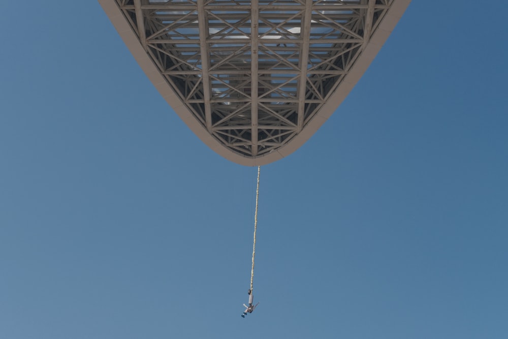 a parasailer is suspended from the roof of a building