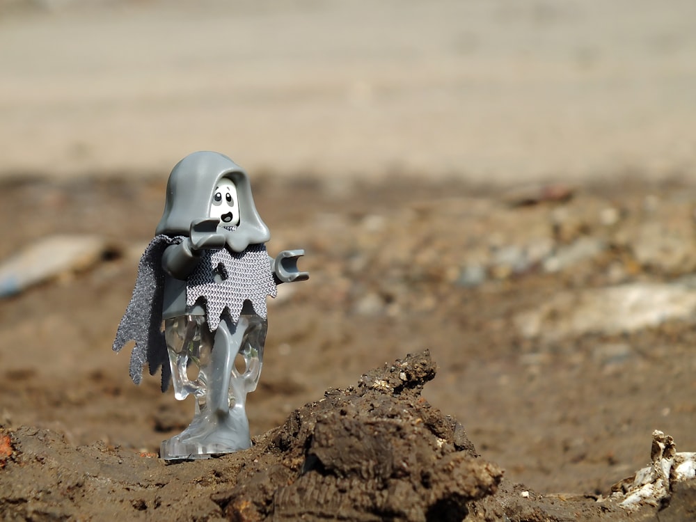 a toy figure is standing in the dirt