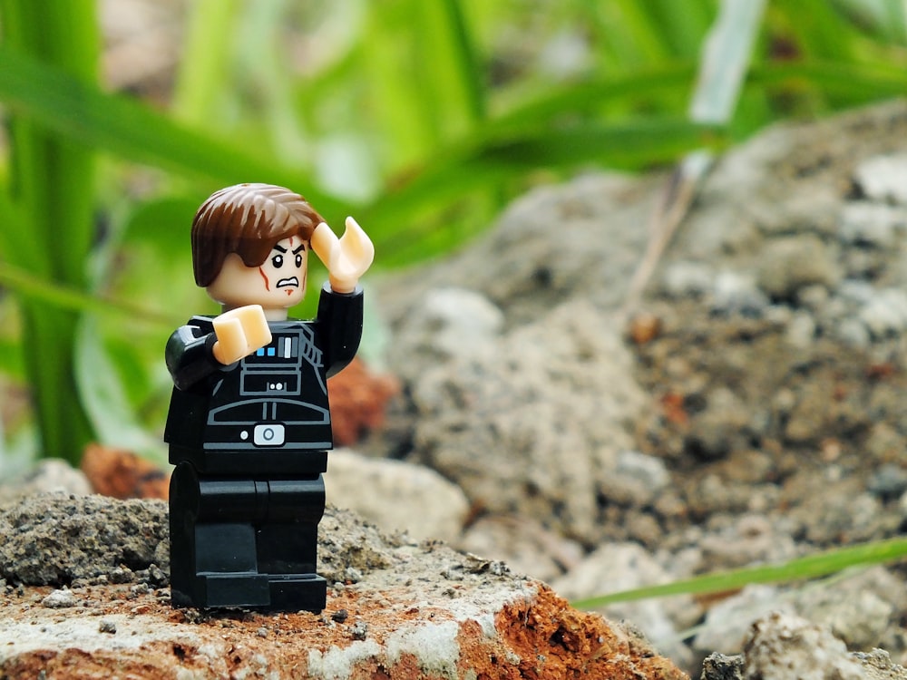 a lego star wars character is standing on a rock