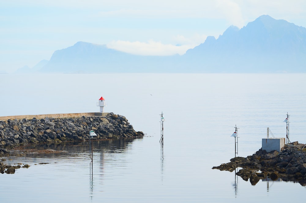 a light house sitting on top of a small island in the middle of the ocean