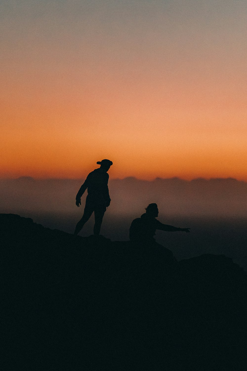 Un par de personas de pie en la cima de una montaña