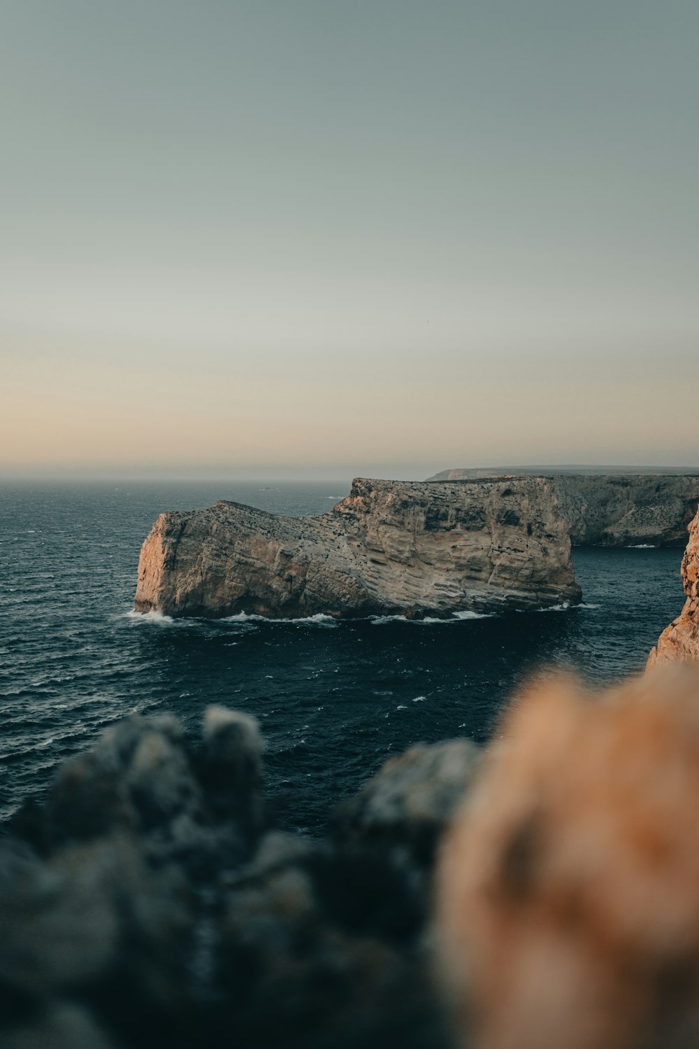 a rock formation in the middle of a body of water