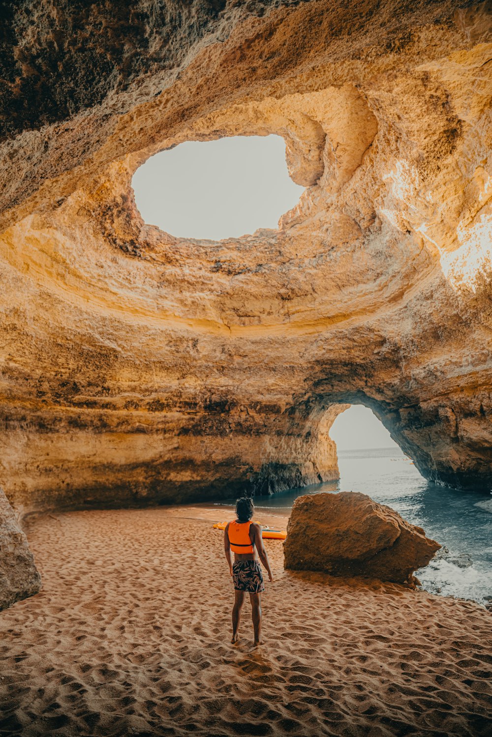 a person standing on a beach with a surfboard