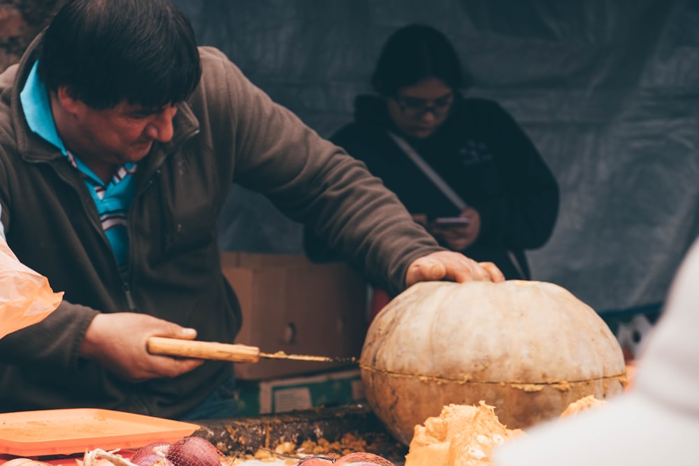 a man is carving a pumpkin on a table