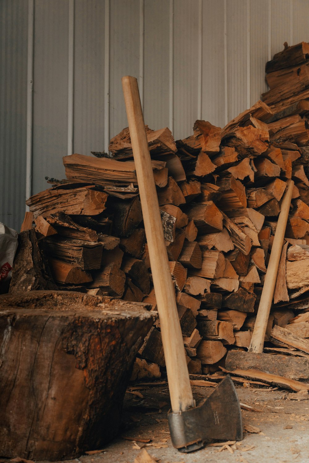 a pile of wood sitting next to a pile of shovels