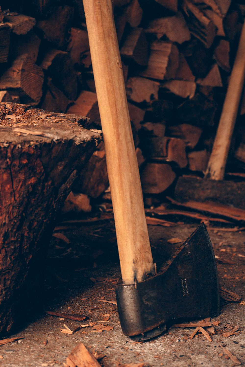 a hammer and an old axe in front of a pile of wood