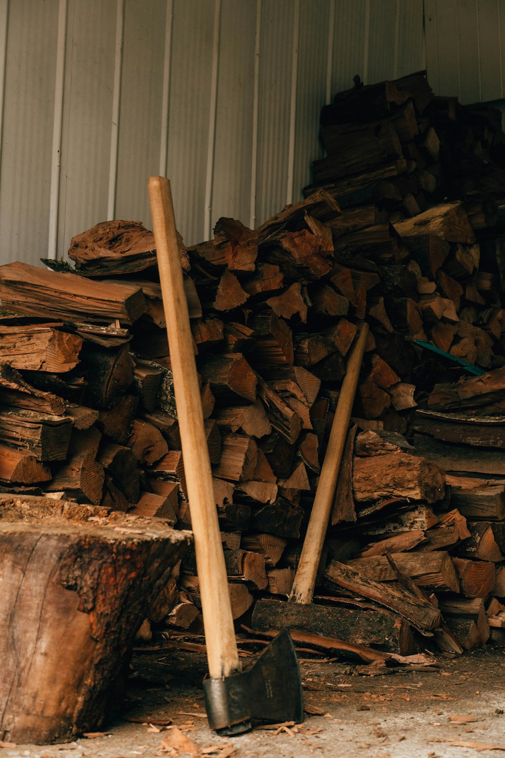 a pile of wood with a shovel next to it