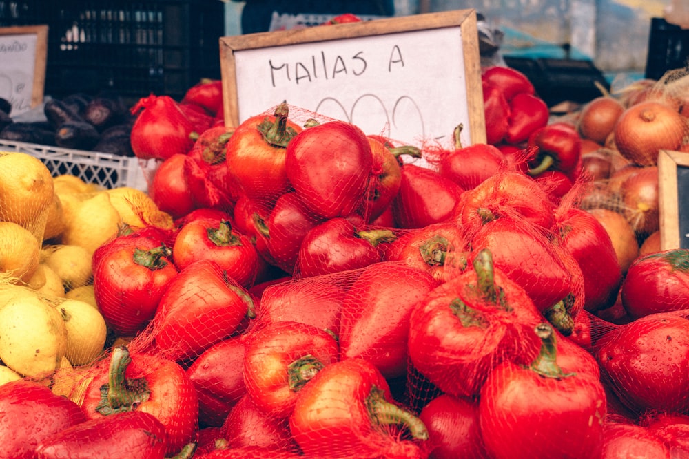 a pile of red apples sitting next to a pile of yellow apples