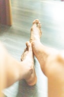 a close up of a person's bare feet on a wooden floor