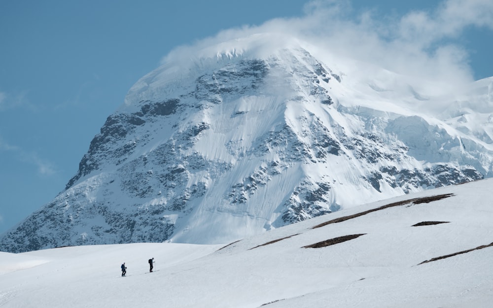 two people standing on a snow covered mountain