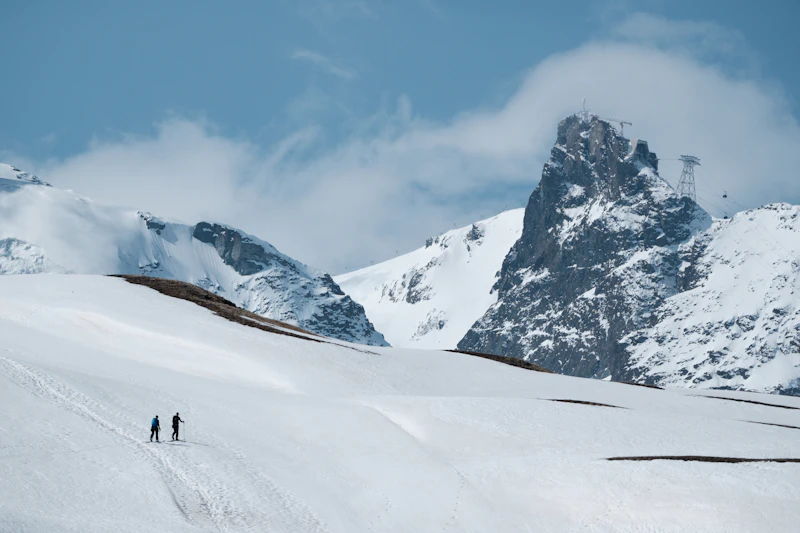 A pair of skiers carving down a snow-covered slope above Zermatt