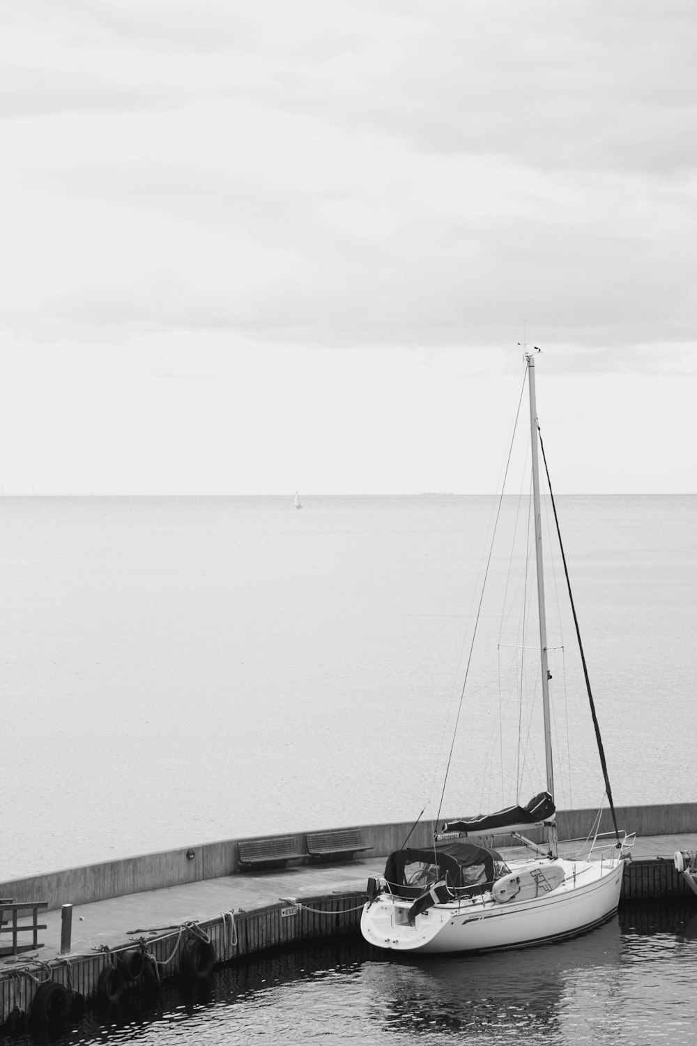 a sailboat is docked at a pier by the water