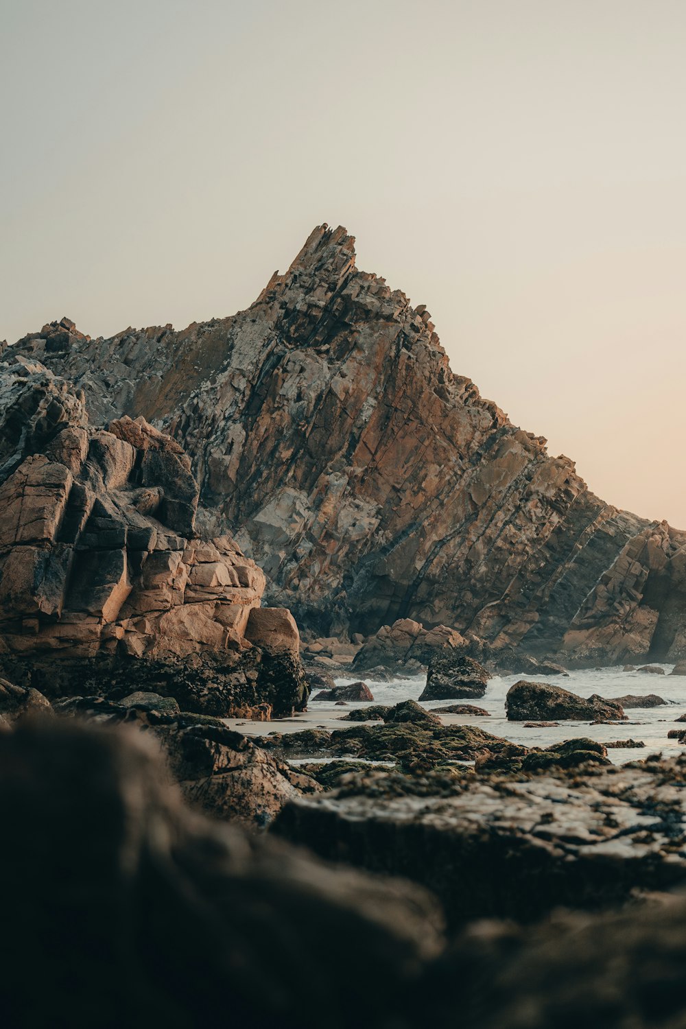 a rocky beach with a mountain in the background