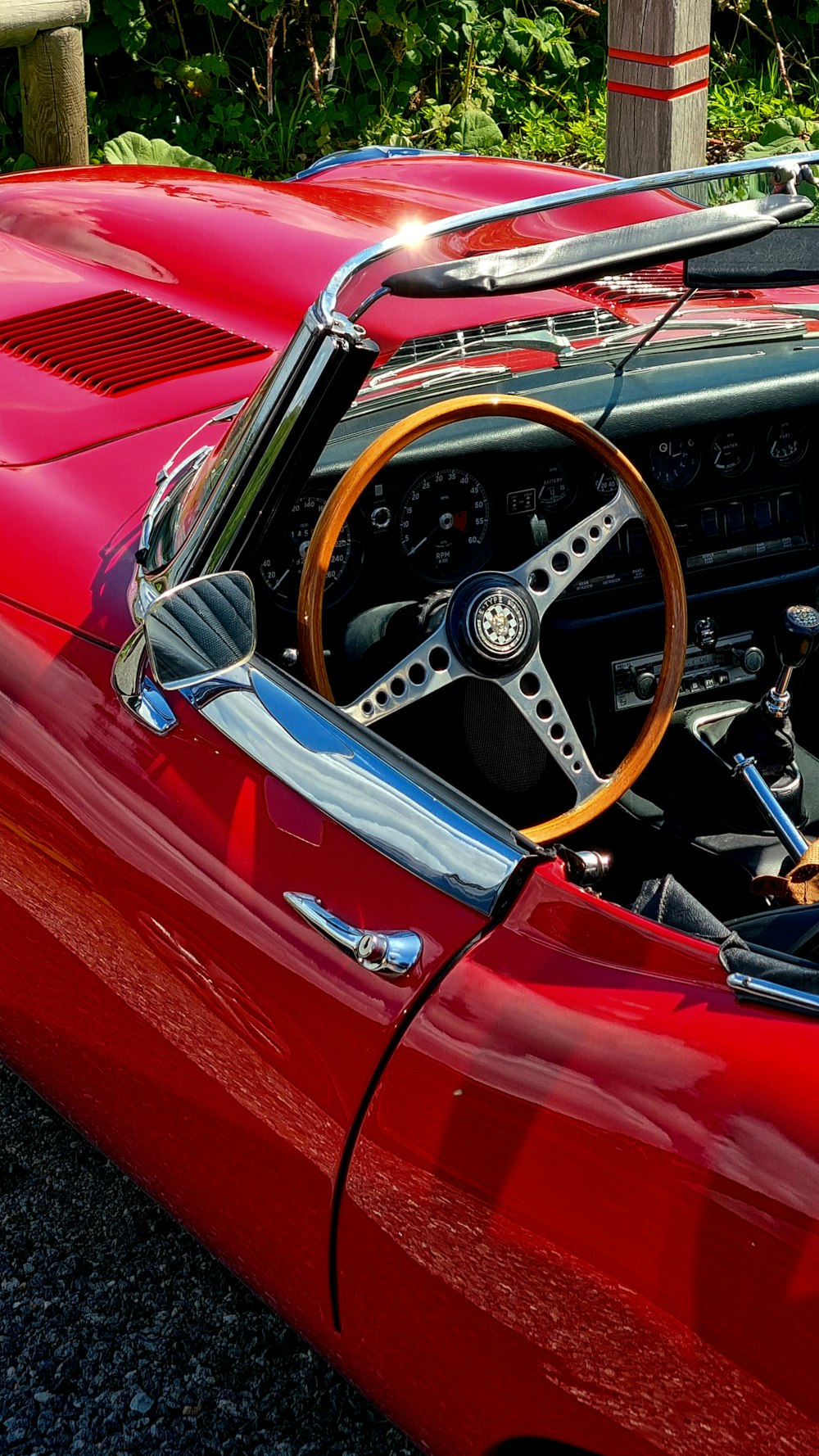 a red sports car with a wooden steering wheel