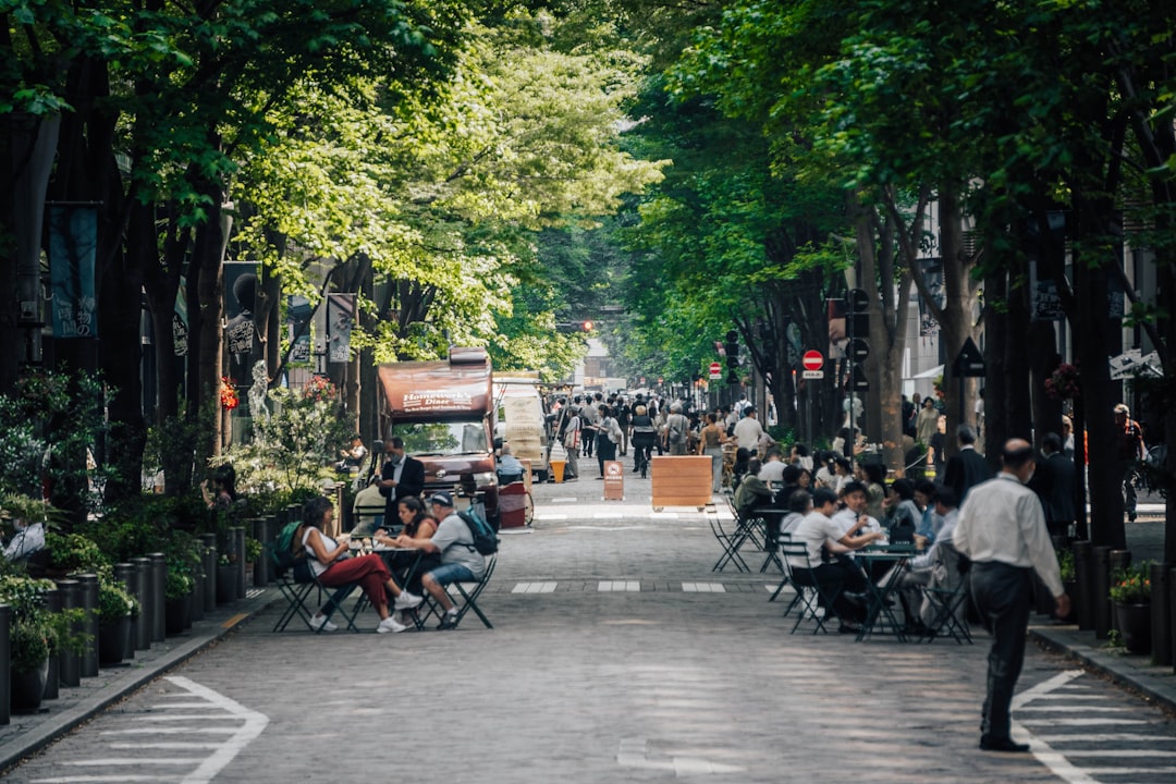 a group of people sitting at tables on a street, Tokyo city center street