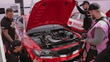 A team of professionals inspecting a vehicle.