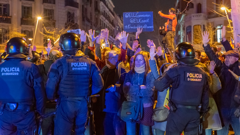 a group of police officers standing in front of a crowd of people