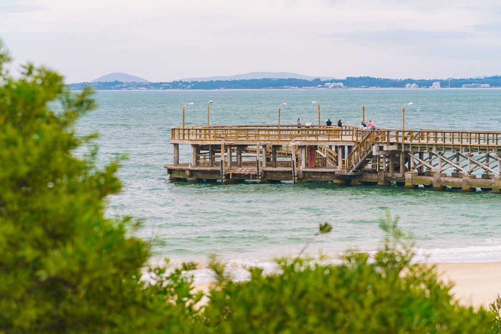 a pier on a beach with people standing on it