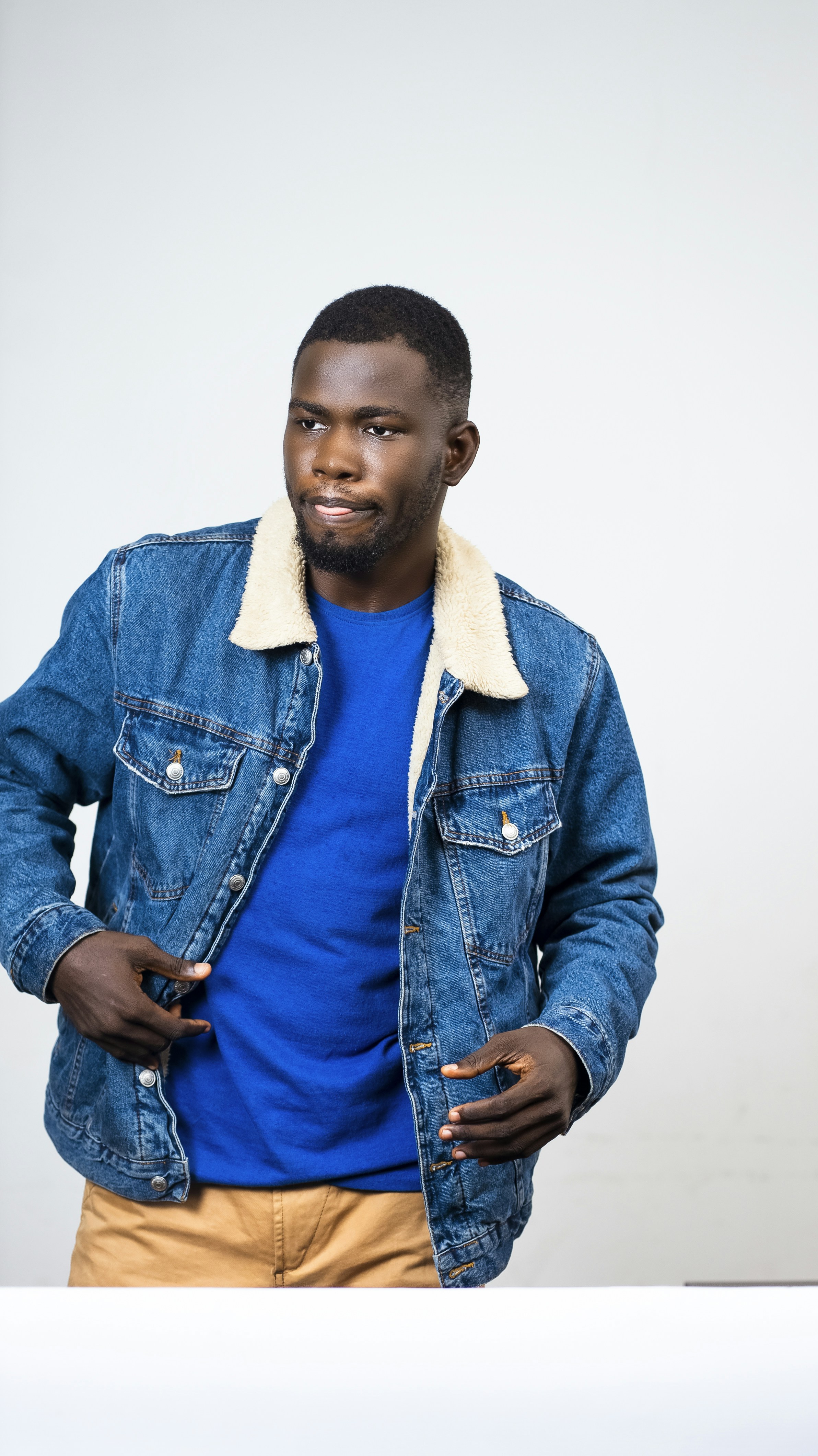 a man in a blue shirt and jean jacket