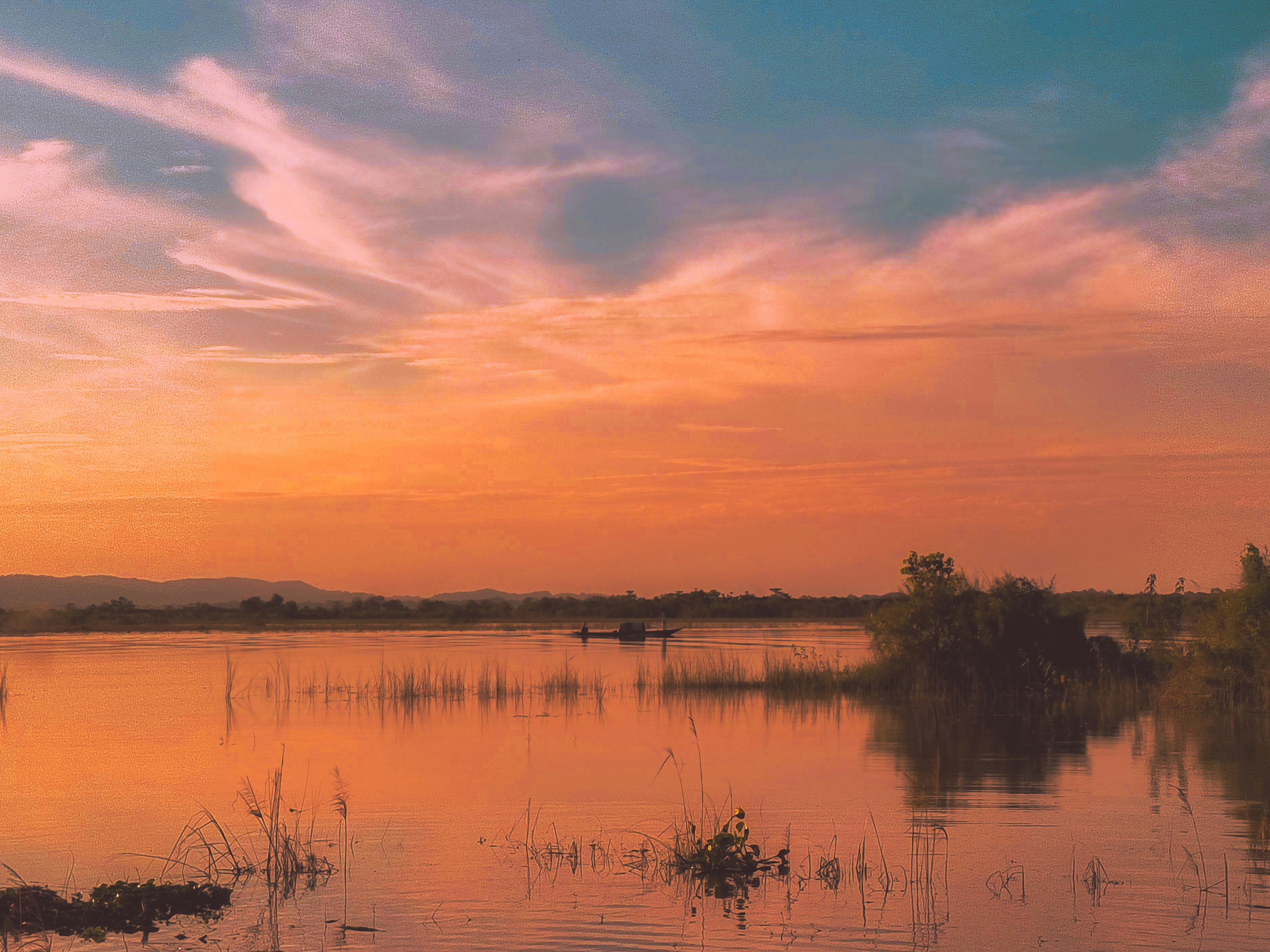 Dal Lake romantic sunset with boat silhouette, soft pink and orange sky, serene water reflection