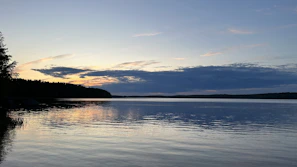 Wide-angle view of a serene lake reflecting the fiery colors of dusk