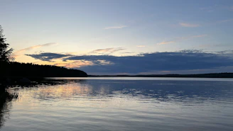 Wide-angle view of a serene lake reflecting the fiery colors of dusk