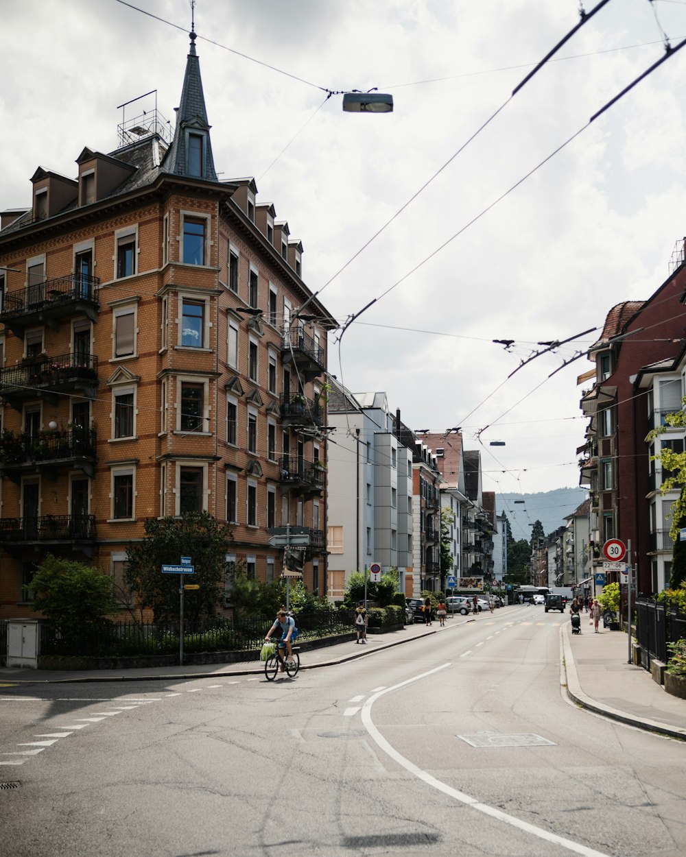 a man riding a bike down a street next to tall buildings