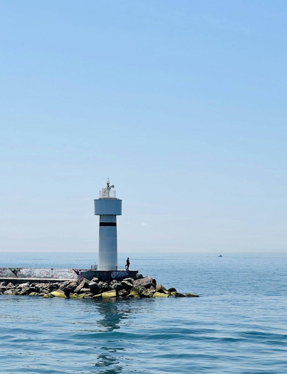 a light house sitting on top of a rock in the middle of the ocean