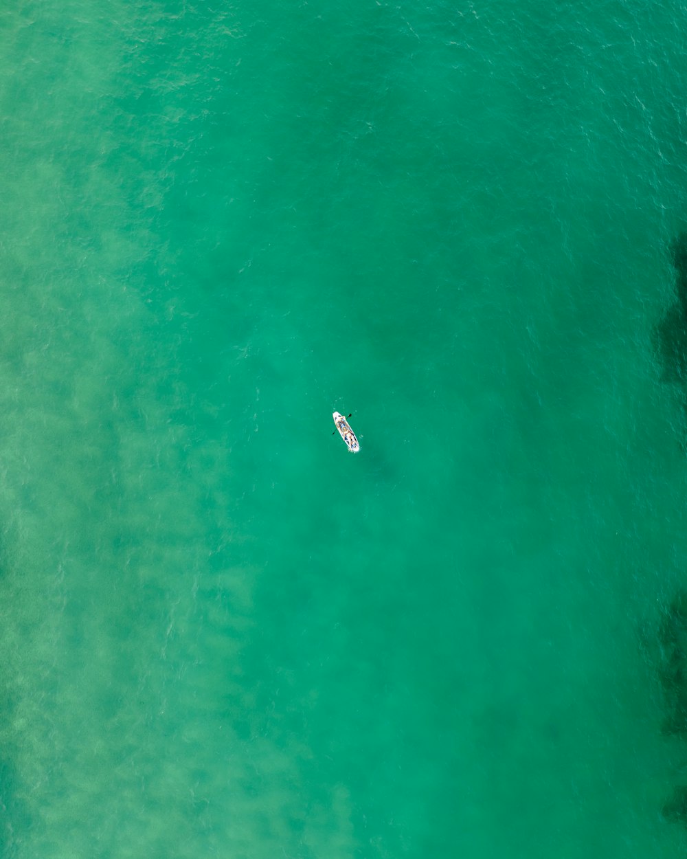 an aerial view of a boat in the ocean